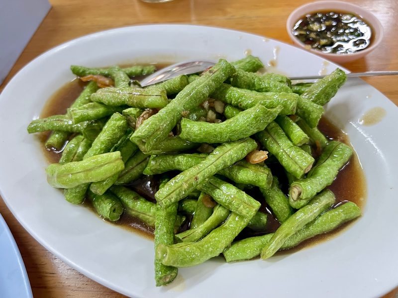 ถั่วฝักยาวผัดเจี๋ยนกับกุ้งแห้งจานใหญ่ มีช้อนกลางวางพาด