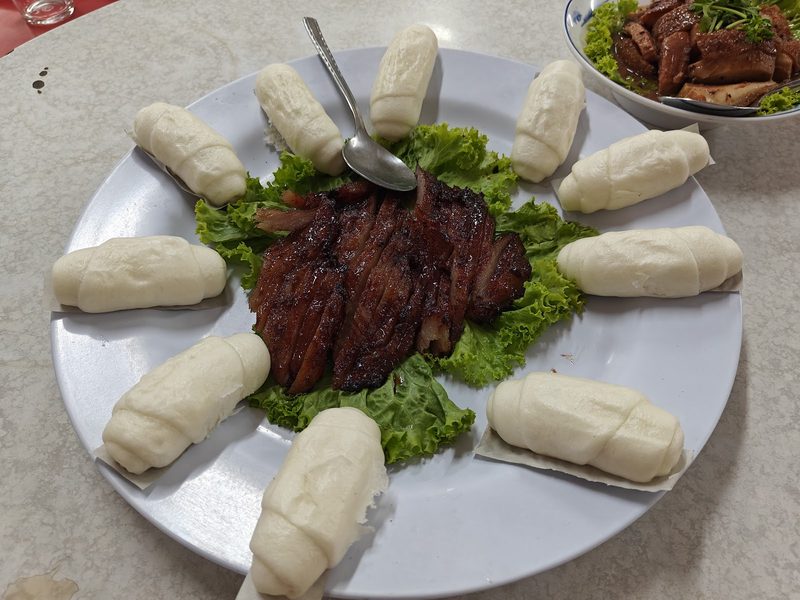 หมั่นโถวขาวนวลเรียงเป็นวงล้อมหมูแดงหั่นชิ้นตรงกลางจาน